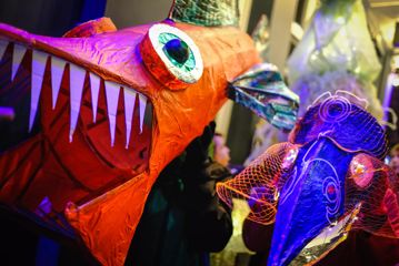 Close up of illuminated costumes resembling fish.