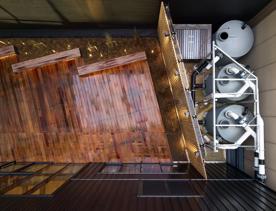 Bird-eye view of the courtyard at Tākina with rainwater capture tanks on the right hidden behind a screen next to a timber desk.