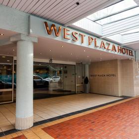 The exterior of West Plaza Hotel, with a tiled floor and large sliding doors.