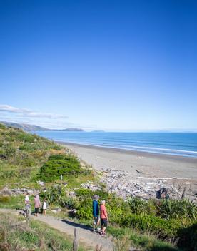 Five people walking along the beach at Queen Elizabeth Regional Park.