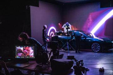 On set of a movie at Avalon Studios in Lower Hutt where they are filming inside a car, with purple lighting surrounding.