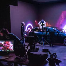 On set of a movie at Avalon Studios in Lower Hutt where they are filming inside a car, with purple lighting surrounding.