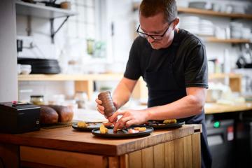 Owner and head chef at Hillside Kitchen, Asher Boote, plates a dish.