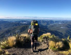 A hiker on the summit of a mountain range.