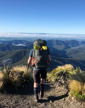 A hiker on the summit of a mountain range.