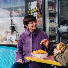 Two customers sharing a meal at a small table inside Huckle & Co. in Seatoun.