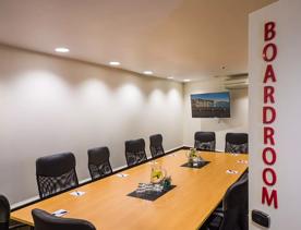 The boardroom inside West Plaza Hotel, where 12 seats sit around a table.