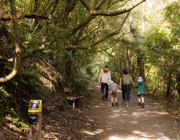 Two adults and two kids walking on a trail at Ōtari-Wilton's Bush