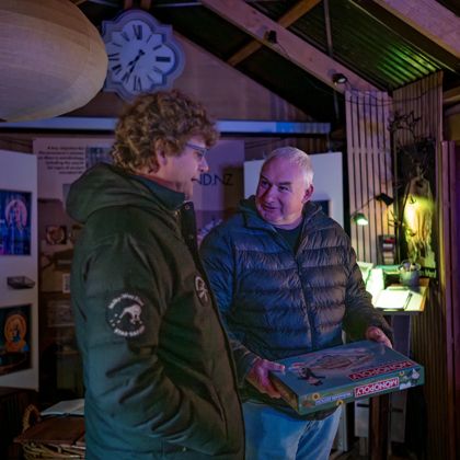 Two people in puffer jackets stand and chat inside a small cabin at Star Safari.