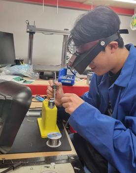 A participant in The Summer of Engineering program working on their Clutterbot project.