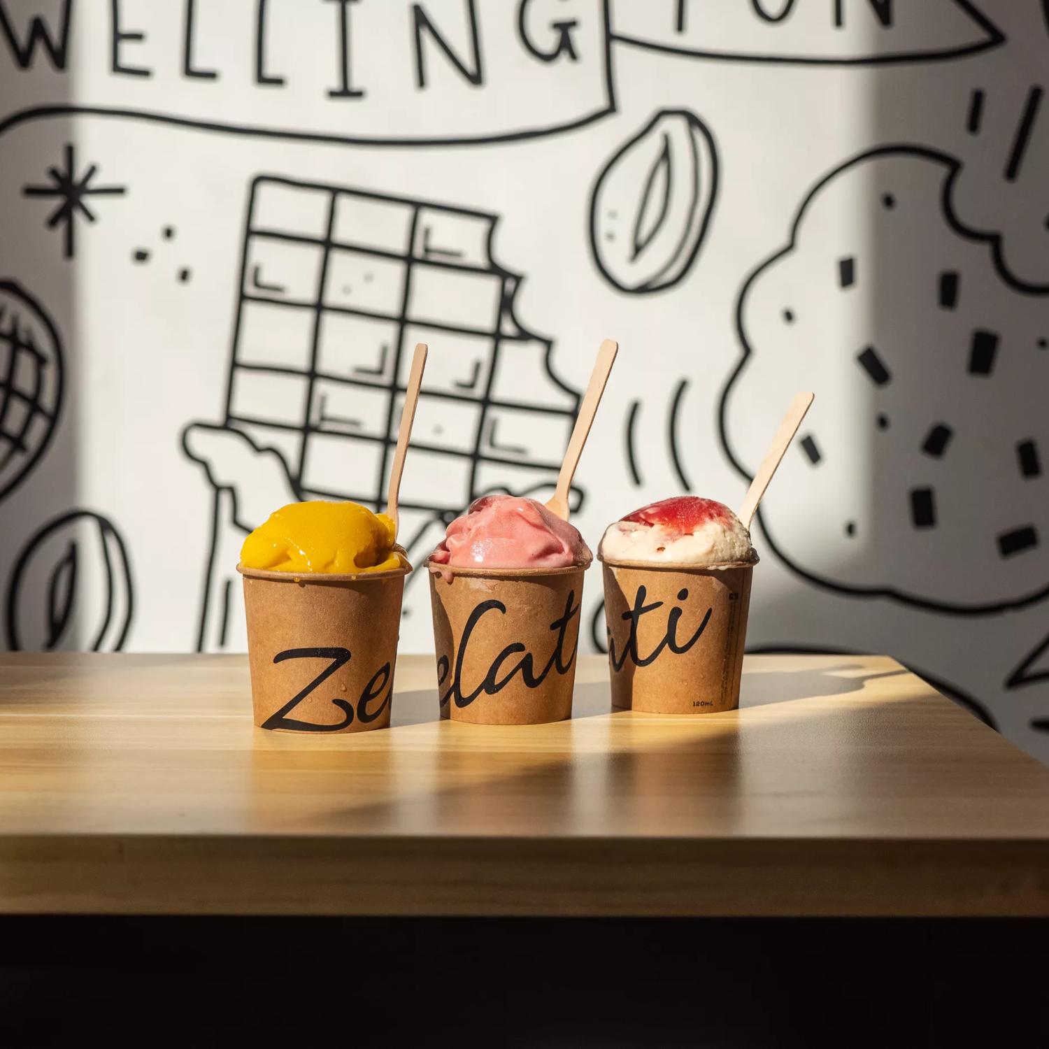 3 tubs of ice cream and sorbet on a table inside Zelati Dessert Cafe.