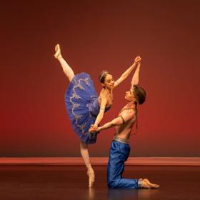 Two dancers perform on stage.