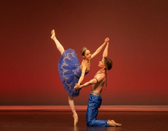 Two dancers perform on stage.