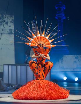 Curves Ahead by Grace DuVal at the World of WearableArt 2024 Show is orange and made of road works plastic and cones.