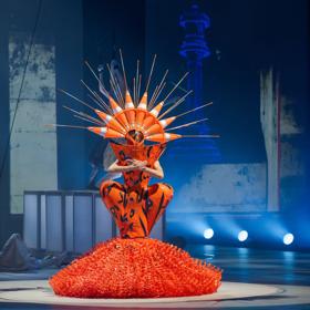 Curves Ahead by Grace DuVal at the World of WearableArt 2024 Show is orange and made of road works plastic and cones.