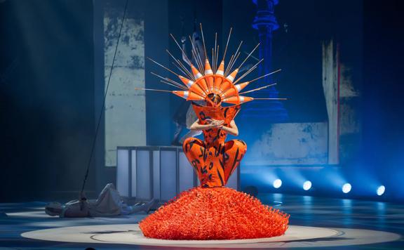 Curves Ahead by Grace DuVal at the World of WearableArt 2024 Show is orange and made of road works plastic and cones.