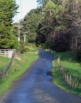 Mangaroa Valley Road screen location, a scenic rural setting with native forest, farmland, and a mountainous backdrop.