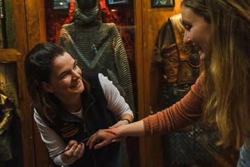 A person gets a fake wound on their hand by a Wētā employee at the Wētā Cave.