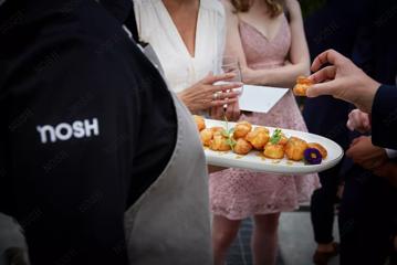 A platter of pastry puff entrées is passed out at an event.