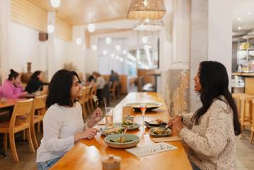 Two friends enjoy food and drinks at Loretta.