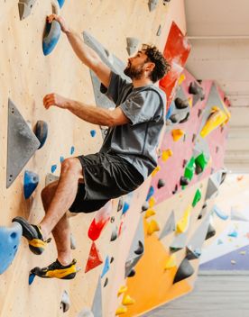 Person bouldering on an indoor climbing wall at Faultline Climbing Gym on Willis Street in Wellington.