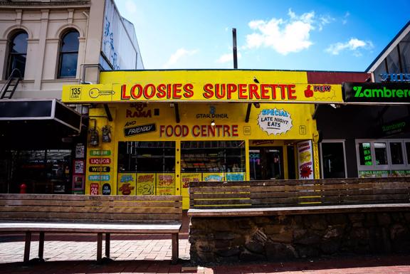The storefront of Loosies Superette. It's a small restaurant, panted in yellow with retro lettering. 