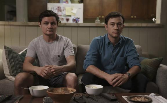 A still from the TV show Mr. Corman. Joseph Gordon-Levitt as Josh Corman sits on a couch next to Arturo Castro as Victor.