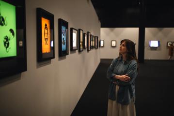 A person looks at screen prints displayed at The Art of Banksy exhibition.