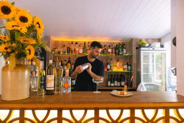 A staff member behind the bar mixing drinks at Hey Coastie Eatery.