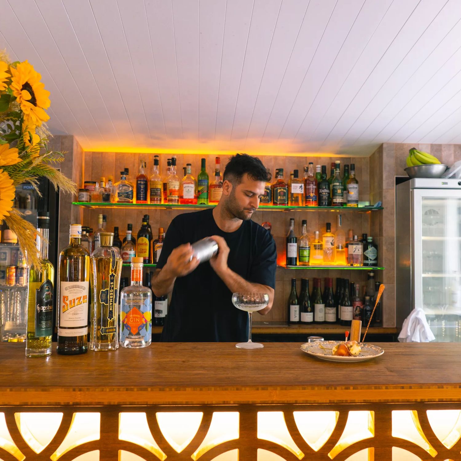 A staff member behind the bar mixing drinks at Hey Coastie Eatery.