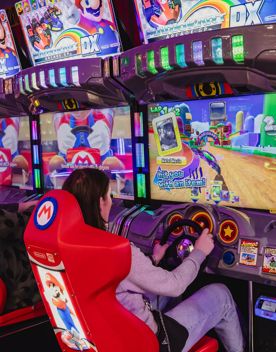 Two people play Super Mario racing arcade game machines in Holey Moley, the mini golf course and bar at Willis Lane located in the Central Business District of Wellington.