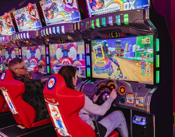 Two people play Super Mario racing arcade game machines in Holey Moley, the mini golf course and bar at Willis Lane located in the Central Business District of Wellington. 