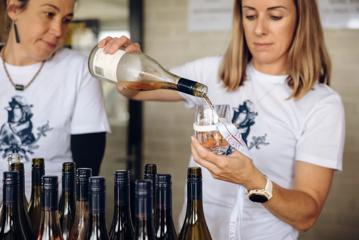 A person pouring a glass of rosé.