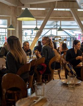 Customers inside Kisa sitting at tables and chatting, enjoying their meals.