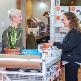 Customer being greeted at Goodnature with a range of pest traps in boxes in the background.