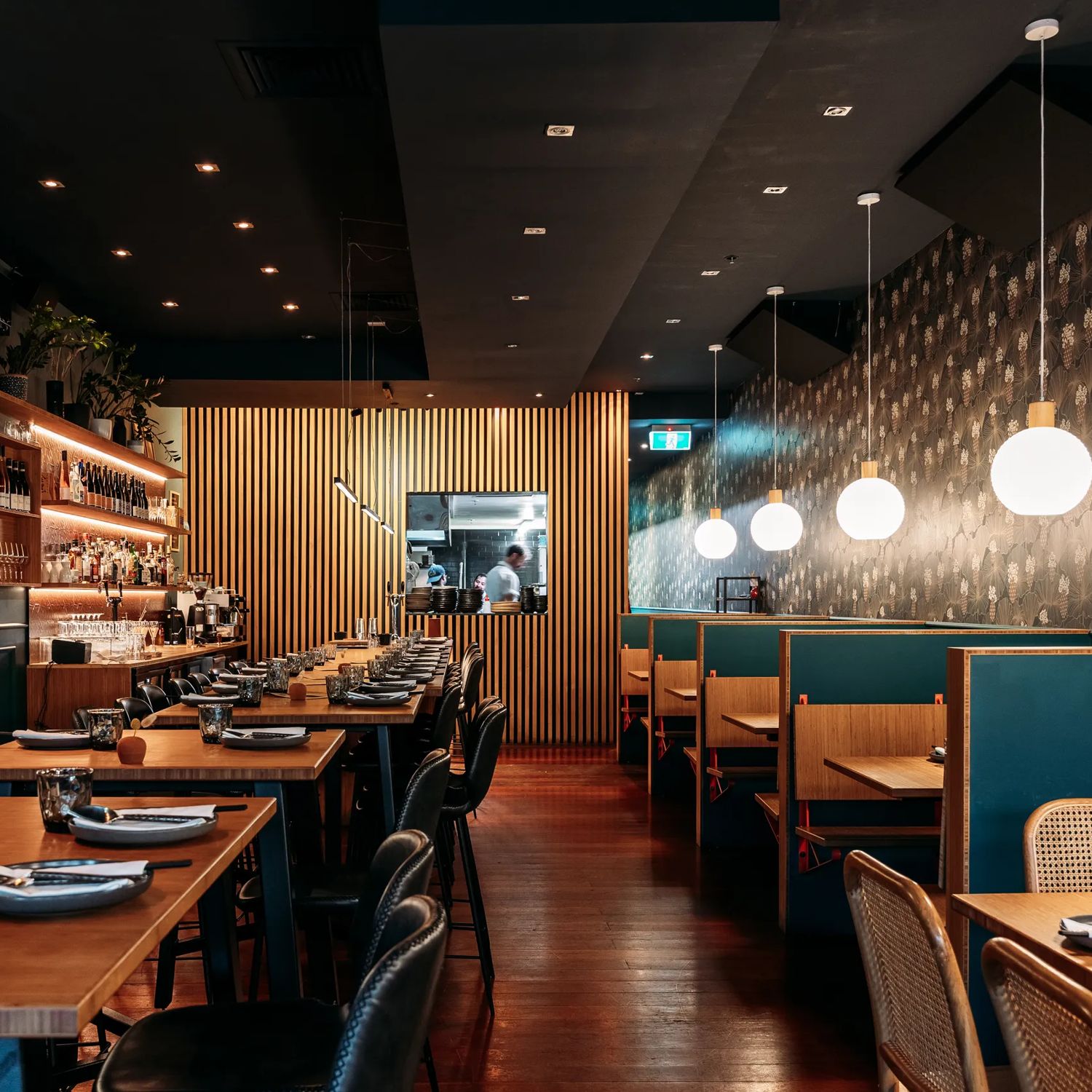 The interior of Koji in Mount Victoria. There is a black roof  is moody, with lantern lights and leather and blue velvet bench seats.