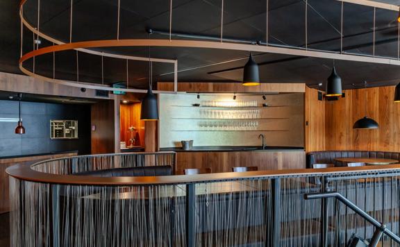 The interior of Alma House in Mount Cook. The brown hues of the leather booths and wood walls give an intimate and moody atmosphere.