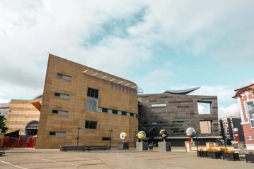 The Large concrete exterior of Te Papa, with 4 large globe statues outside.