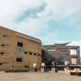 The Large concrete exterior of Te Papa, with 4 large globe statues outside.