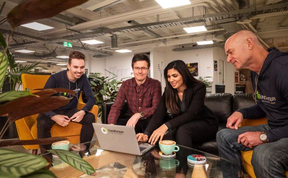 Four people from DataTorque working on a laptop.