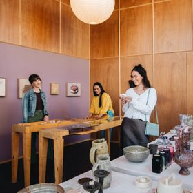 Three friends are shopping for pottery.