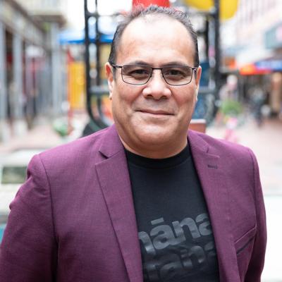 Headshot of Paul Retimanu, a board member of WellingtonNZ, smiling in front of the Bucket Fountain.