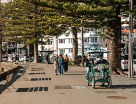 Oriental Parade, where a croc bike is seen going down the path and people walking along the waterfront.