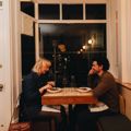 A couple on a dinner date enjoy food and wine at a small table by the front window at Rita, a small restaurant in Aro Valley, Wellington.