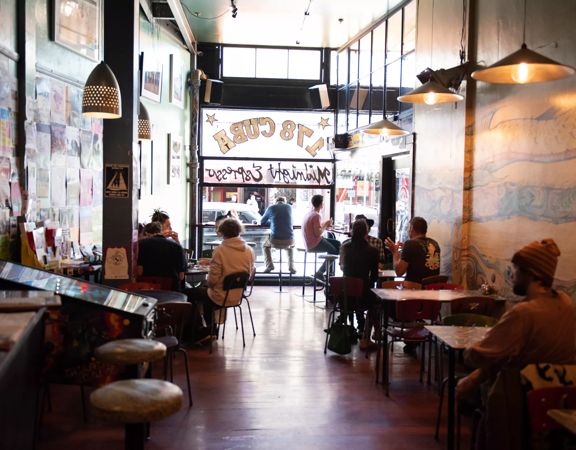 Patrons enjoying food and coffee inside Midnight Espresso, a popular café on Cuba Street in Wellington.