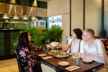 Three friends enjoy sharing plates and drinks at Hummingbird Restaurant & Lounge.