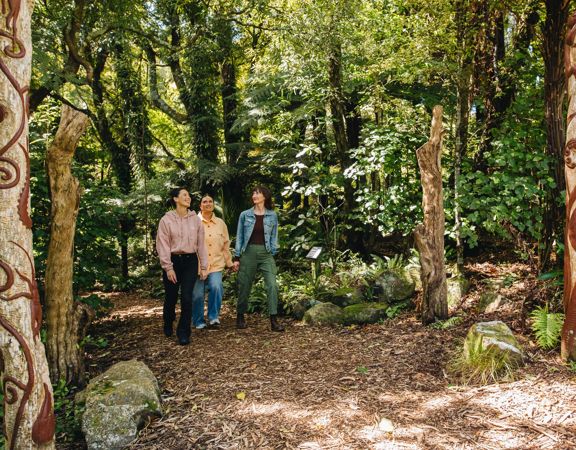 Three people waking through native forest at Ōtari-Wilton's Bush in Wellington