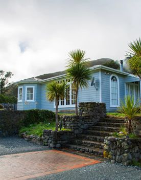 The screen location of Ōrongorongo Station, with many buildings, old and new, as well as views of the ocean and mountains.