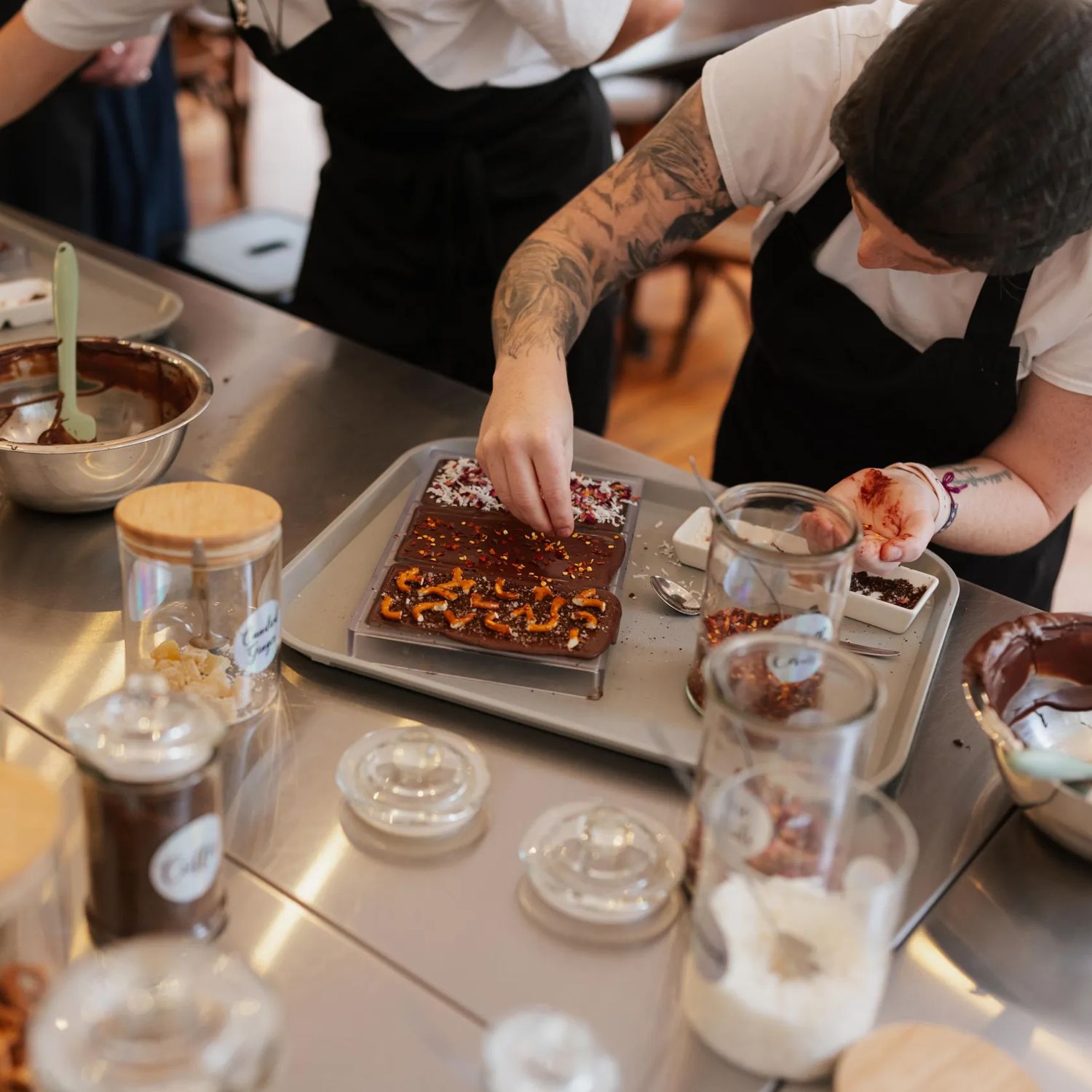 A person decorates chocolate bars at Wellington Chocolate Factory.
