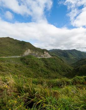 The screen location of Remutaka Summit, wit views of surrounding peaks, lush green bush and steep roads cut into the sides of the mountains.